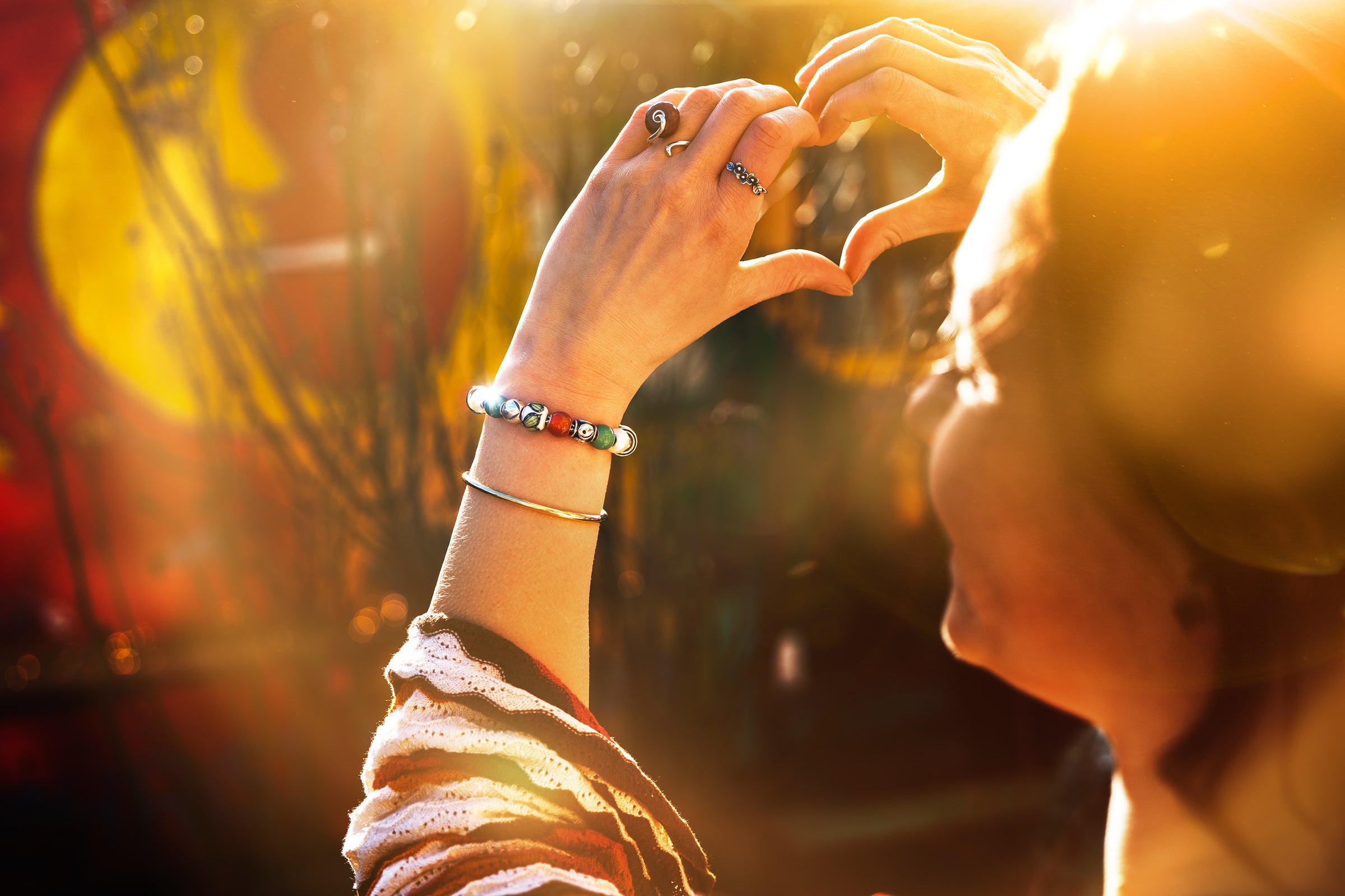 model wearing a beaded bracelets and making heart sign with her hands